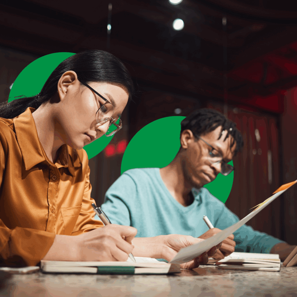 a man and woman writing on paper